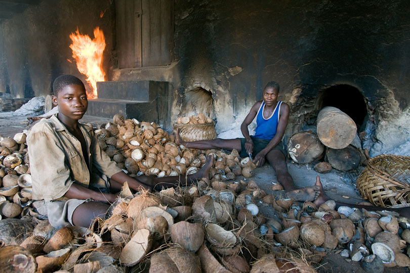 Boys removing the copra from the shells.